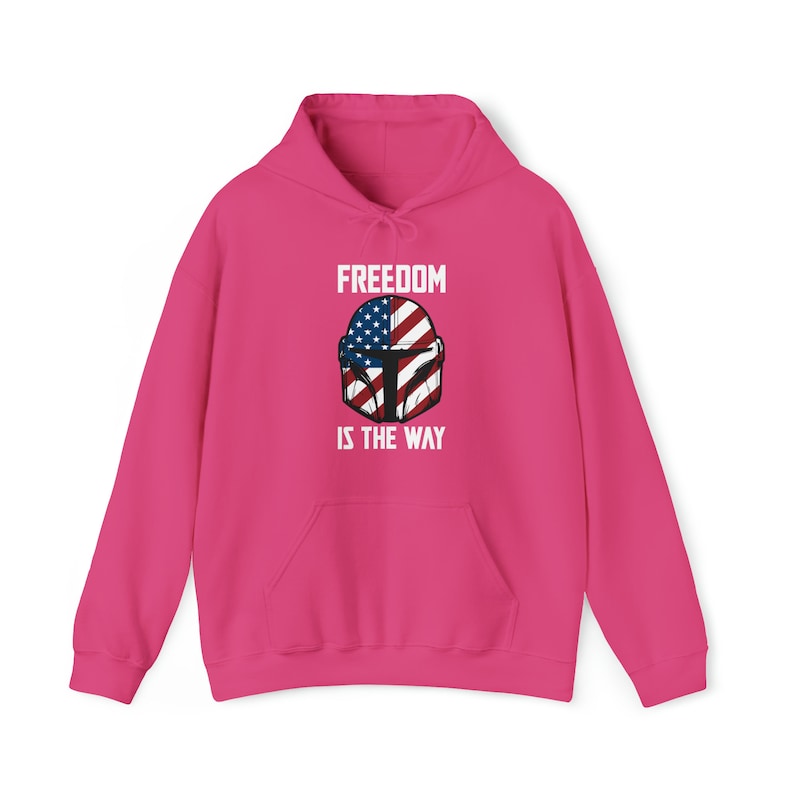 May include: A bright pink hooded sweatshirt with a front pocket and drawstring. The front features a graphic of a helmet with the American flag design and the text "FREEDOM IS THE WAY" in white.