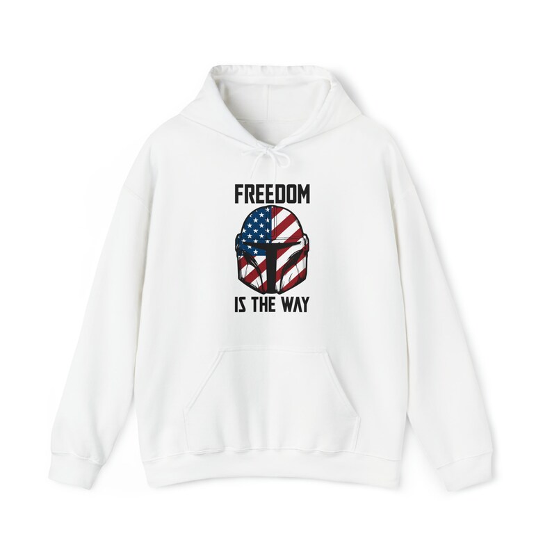 May include: White hooded sweatshirt with a front pocket and drawstring. The design features a helmet graphic with the American flag and the text "FREEDOM IS THE WAY" in black.