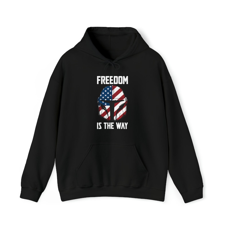 May include: Black hooded sweatshirt with a front graphic featuring a helmet design incorporating the American flag. The text "FREEDOM IS THE WAY" is printed above and below the helmet design in white block letters. The sweatshirt has a front pocket and a drawstring hood.