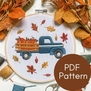 May include: A blue pickup truck with a wooden bed filled with orange pumpkins. The truck is surrounded by fall leaves in shades of orange, red, and yellow. The image includes the text "PDF Pattern".