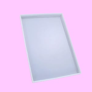 Könnte beinhalten: Ein weißes rechteckiges Tablett mit einer glatten Oberfläche. Das Tablett ist aus robustem Material gefertigt und hat ein klares, modernes Design.