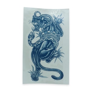May include: A blue and white tattoo design of a panther wrapped around a snake. The panther is facing forward with its mouth open and the snake is wrapped around its body.