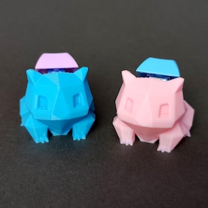 May include: Two 3D printed Pokemon figures, one blue and one pink, with a small keycap on top of each.