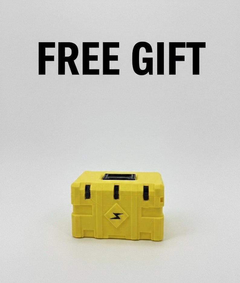 May include: A yellow box with black accents and a lightning bolt symbol on the front. The text "FREE GIFT" is displayed above the box in bold, black letters. The box is sitting on a white surface.