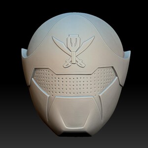 Peut inclure: Un casque en plastique blanc avec un design détaillé. Le casque a un symbole noir sur le dessus et une visière noire avec un motif en grille.