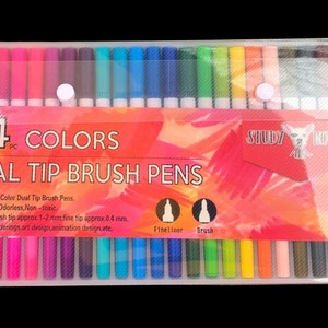May include: A clear plastic case containing 24 dual tip brush pens. The pens have a fine tip and a brush tip. The case has a red and orange background with the text "24 COLORS DUAL TIP BRUSH PENS" and "STUDY NOTES".