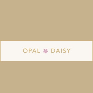 May include: White banner with the text "OPAL * DAISY" in gold lettering with a pink flower symbol between the words.