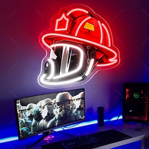May include: A red and white neon sign shaped like a firefighter's helmet. The sign is mounted on a wall above a computer monitor displaying a Star Wars image. The room is lit with blue and red lights.
