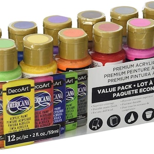 Könnte beinhalten: Ein Set aus 12 DecoArt Americana Acrylfarbenflaschen in verschiedenen Farben, jeweils 59 ml. Die Kartonverpackung enthält den Text Premium Acrylic Paint, Value Pack und 12 pc/pz 2 fl. oz./59ml sowie Symbole für verschiedene Bastelanwendungen.