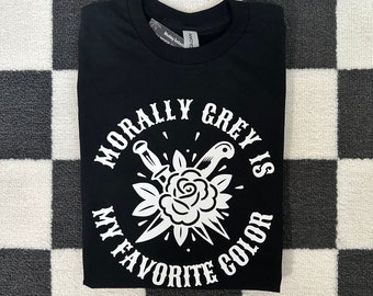 May include: Black t-shirt with a white graphic design. The graphic features a rose with two daggers and the text "Morally Grey Is My Favourite Colour".