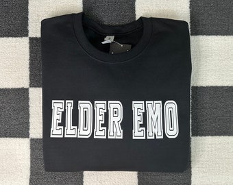 May include: Black sweatshirt with white text that reads "ELDER EMO" in a varsity-style font.