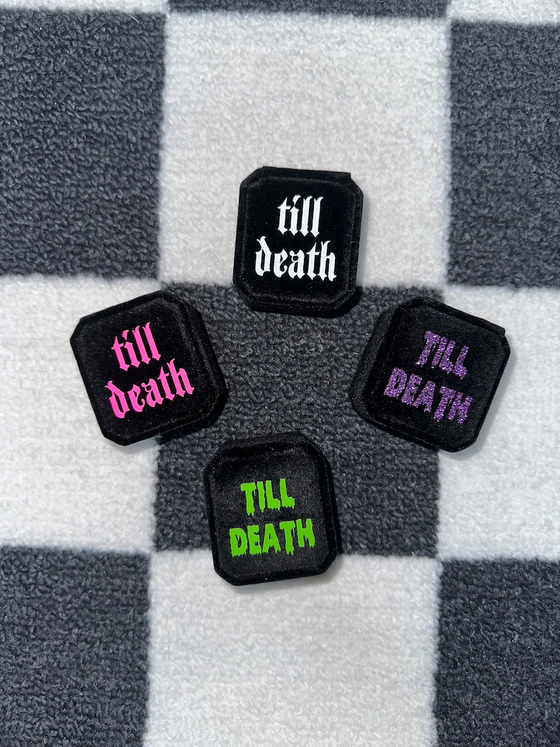 K&ouml;nnte beinhalten: Vier schwarze quadratische Patches mit dem Text "till death" in verschiedenen Farben: wei&szlig;, rosa, lila und gr&uuml;n.