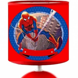 Peut inclure: Lampe de table rouge avec une base ronde et un abat-jour rouge représentant un personnage de Spiderman. L'abat-jour est bordé de bleu avec des étoiles blanches et une bannière blanche avec des étoiles.