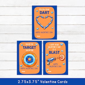 May include: Three Valentine's Day cards with blue borders and orange centers. The cards feature playful designs with text like "Follow Your Dart," "You're My Target Valentine," and "I Hope Your Valentine's Day Is a Blast."