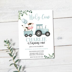 Puede incluir: Una invitaci&oacute;n de cumplea&ntilde;os azul y blanca con una vaca de dibujos animados que viaja en un tractor de juguete azul. La invitaci&oacute;n dice "Holy Cow Charlie cumple un a&ntilde;o!" e incluye detalles para la fiesta, como la fecha, la hora, la ubicaci&oacute;n y la informaci&oacute;n de RSVP.