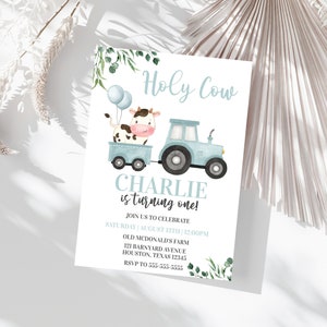 Puede incluir: Una invitaci&oacute;n de cumplea&ntilde;os azul y blanca con una vaca y un tractor de dibujos animados. El texto dice "Holy Cow Charlie is turning one!" con detalles para la fiesta.