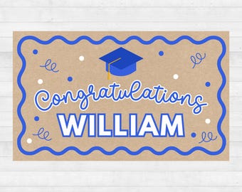 May include: A graduation card with a kraft paper background. The card features blue text that reads "Congratulations WILLIAM" with a graduation cap icon. The card has a blue wavy border and decorative elements.