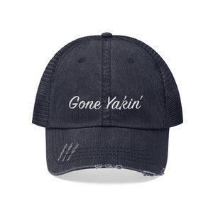 May include: A navy blue distressed trucker hat with a white embroidered design that says "Gone Yakin'"