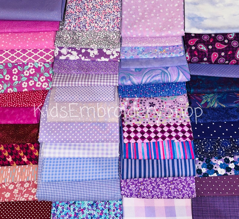 May include: A collection of 40 fabric squares in various shades of purple, pink, and blue. The fabrics feature different patterns, including polka dots, stripes, florals, and paisley. The fabric squares are arranged in rows and columns, creating a visually appealing display.