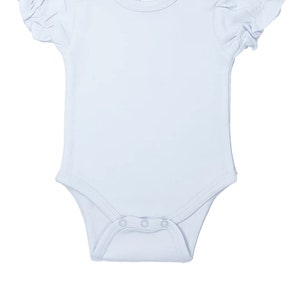 May include: A light blue baby onesie with short sleeves and a ruffled trim. The onesie has a round neckline and snaps at the bottom. The onesie has a label that says "A1 Blanks 3-6M".