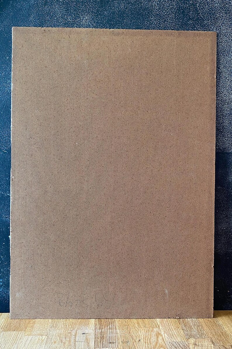 May include: A rectangular, brown, textured board with a woven pattern. The board is set against a dark blue background. The board's surface has a consistent, fine texture.