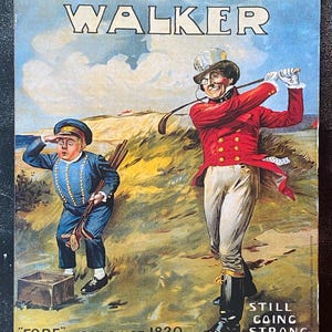 May include: Vintage Johnnie Walker whisky advertisement featuring two figures on a golf course. The text reads "Johnnie Walker" and "Fore-most since 1820." The image has a blue sky background and a golf theme.