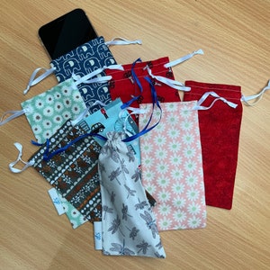 Può includere: Una collezione di otto piccole borse di stoffa con vari motivi, tra cui elefanti, fiori, auto e libellule. Le borse sono realizzate in cotone e hanno chiusure con coulisse. Sono perfette per riporre piccoli oggetti come gioielli, monete o chiavi.