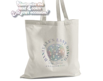 May include: White canvas tote bag with a holographic design that says "Danielle's Last Disco" with a disco ball graphic and "Palm Springs, California" underneath.