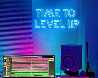 Puede incluir: Un letrero de neón azul con el texto "TIME TO LEVEL UP" en una pared con iluminación rosa y azul. Un altavoz blanco y un monitor de computadora están en primer plano.