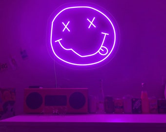 May include: A purple neon light in the shape of a smiley face with X's for eyes and a tongue sticking out.