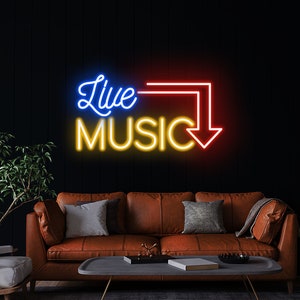Op de afbeelding: Een neonbord met de woorden "Live Music" in blauw, geel en rood. Het bord is gemonteerd op een zwarte muur boven een bruine leren bank.