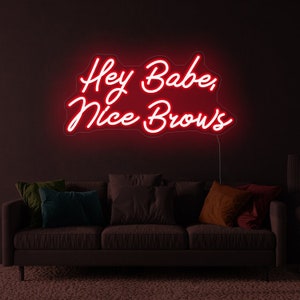 May include: Red neon sign with white lettering that reads "Hey Babe, Nice Brows".