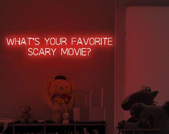 Może przedstawiać: Czerwony neonowy znak z tekstem "What's your favorite scary movie?" na czerwonej ścianie. Znak jest podświetlony i świeci.