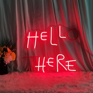 Puede incluir: Letrero de neón rojo con las palabras "HELLO THERE" en un contorno blanco.