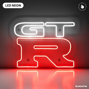 Könnte beinhalten: LED-Neon-Schild mit den Buchstaben "GT" in Weiß und dem Buchstaben "R" in Rot. Das Schild ist an einer Wand befestigt und spiegelt sich auf der darunter liegenden Oberfläche. Der Text "LED NEON" befindet sich in einem weißen Rechteck oben links.