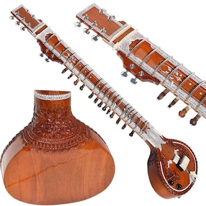 May include: A traditional Indian sitar with a carved wooden body, intricate silver inlay, and a long neck with multiple strings.