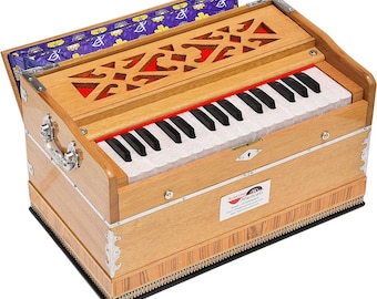 May include: A wooden harmonium with a keyboard of black and white keys. The instrument has a light brown finish with decorative cutouts and red accents. The top lid is open, revealing a patterned interior. The harmonium has a silver handle and metal corner accents.