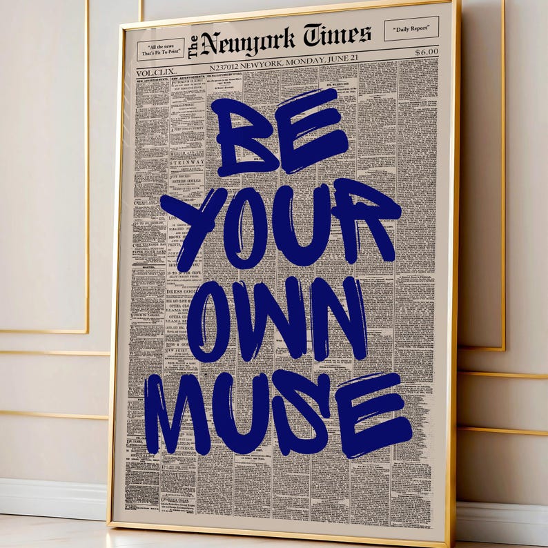 以下が含まれることがあります： ヴィンテージ新聞を背景に、「BE YOUR OWN MUSE」という言葉が太字の青い文字で書かれた額入りのプリント。プリントは金色のフレームで額装されています。新聞の見出しには「The Newyork Times」と書かれています。壁の装飾に最適です。