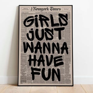 以下が含まれることがあります： 「GIRLS JUST WANNA HAVE FUN」の文字が大きく黒字で書かれたフレーム入りプリント。背景は新聞印刷で、上部には「The Newyork Times」の文字。