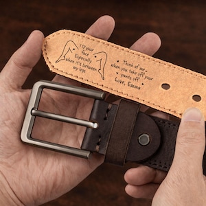 Puede incluir: Un cinturón de cuero marrón con hebilla plateada. El cinturón tiene un mensaje personalizado grabado en el interior, incluyendo el texto "I your face Especially when it's between my legs" y "Think of me when you take off your pants off Love, Emma."