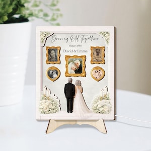 May include: A wooden framed print with the text "Growing Old Together Since 1986 David & Emma". The print features framed photos and a couple in formal attire. The print is displayed on a wooden easel.