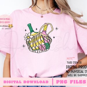 May include: A pink t-shirt with a graphic of two bottles of wine in a green and yellow wicker basket with a pink flower. The text "NOTE** THIS ITEM IS DIGITAL PRODUCT. NO PHYSICAL ITEM WILL BE SHIPPED." is printed on the shirt.