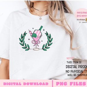 May include: A white t-shirt with a pink and green illustration of a cocktail glass with a bottle inside. The illustration is surrounded by green leaves. The text "NOTE** THIS ITEM IS DIGITAL PRODUCT. NO PHYSICAL ITEM WILL BE SHIPPED." is at the bottom of the shirt.