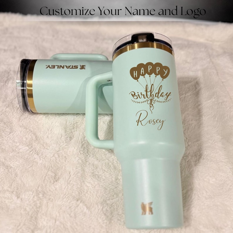 Gold laser engraved Stanley style 40oz tumbler featuring a personalized name, designed as a unique birthday gift for women. Includes a flip straw lid and sturdy handle for convenience and daily use. This insulated tumbler keeps beverages hot or cold for extended periods and offers a stylish and modern look, making it a thoughtful and practical personalized gift.