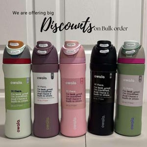 May include: Five Owala insulated water bottles in various colors: beige, purple, pink, black, and green. Each bottle has a push-button lid and a built-in straw. The bottles are 24 oz / 710ml. Text on the bottles reads: "Hi there, I'm leak proof, I'm insulated, And I have a built-in straw."