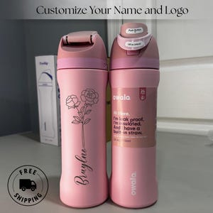Puede incluir: Dos botellas de agua rosas aisladas con diseños florales negros y el texto "Bruylno". Una botella tiene una etiqueta que dice "Hi there. I'm leak proof. I'm insulated. And I have a built-in straw. 710ml."