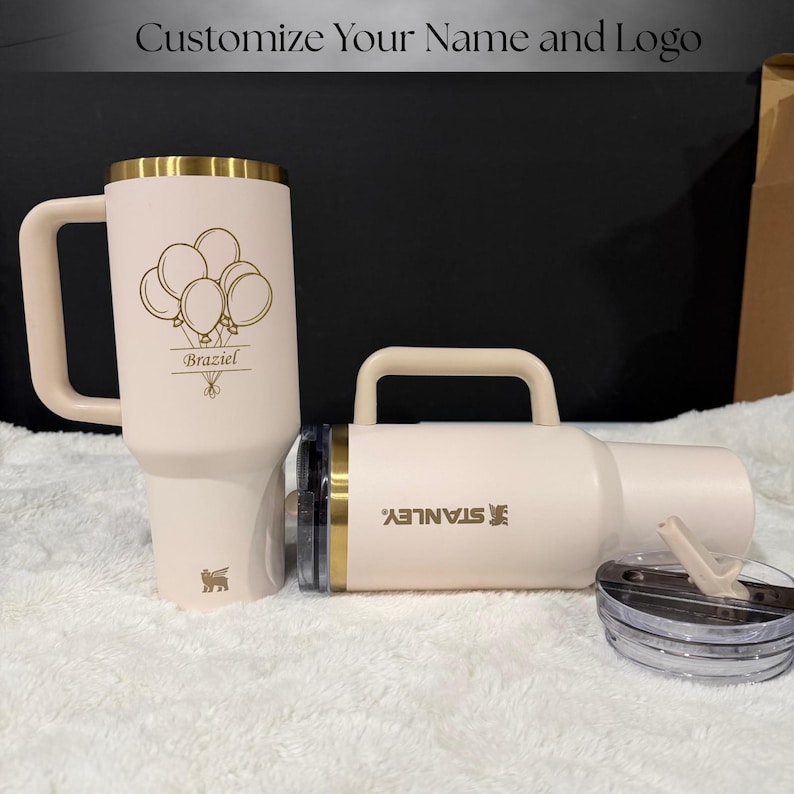 Gold laser engraved Stanley style 40oz tumbler featuring a personalized name, designed as a unique birthday gift for women. Includes a flip straw lid and sturdy handle for convenience and daily use. This insulated tumbler keeps beverages hot or cold for extended periods and offers a stylish and modern look, making it a thoughtful and practical personalized gift.