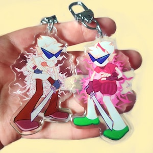 Pode incluir: Dois chaveiros de acrílico transparente com um personagem de desenho animado com cabelo branco, óculos de sol azuis e uma espada. Um tem uma roupa branca e vermelha, o outro uma roupa rosa. Ambos têm chaveiros prateados.