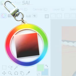 Peut inclure: Un porte-clés en forme de roue chromatique arc-en-ciel avec un carré dégradé noir et rouge au centre. Le porte-clés est doté d'un fermoir en métal argenté.