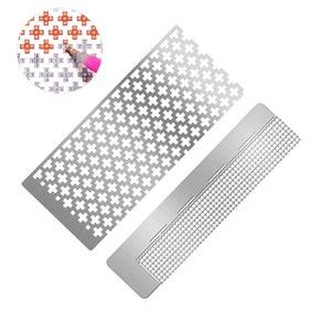 Puede incluir: Dos herramientas de metal para pintura de diamantes. Una herramienta tiene una cuadrícula de cuadrados pequeños, la otra tiene una cuadrícula de cruces.